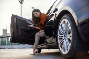 A woman is stepping out of a car, possibly seeking assistance for an emergency tire repair.