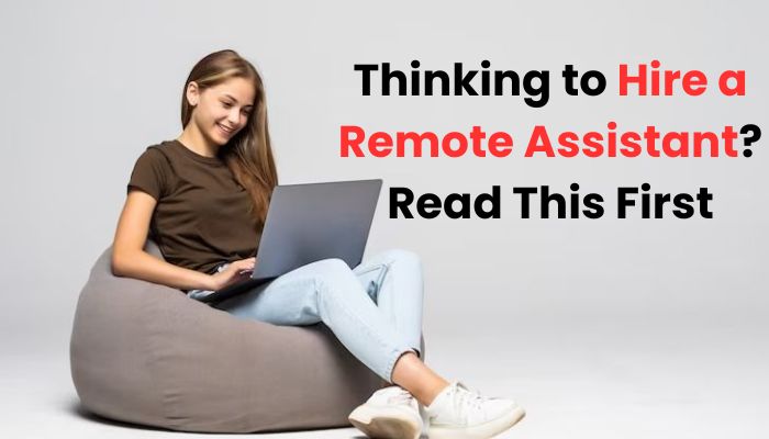 Smiling young woman sitting on a bean bag working on a laptop, with the text 'Thinking to Hire a Remote Assistant? Read This First' displayed beside her