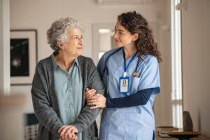 Hospice nurse providing care to a patient at home with family members nearby.