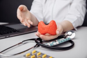 Doctor holding a model of the thyroid gland, representing early diagnosis and treatment of thyroid disorders.