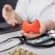 Doctor holding a model of the thyroid gland, representing early diagnosis and treatment of thyroid disorders.