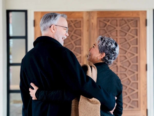 Smiling older couple arm-in-arm entering a resort lobby, part of Chaminade's Golden Years Getaway offer