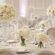 Round banquet tables with white linens and tall white rose centerpieces set for a gala reception at The Adolphus Hotel in Downtown Dallas.