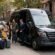 Brooklyn Sprinter Van Service: a chauffeur welcoming a group of travelers with suitcases beside a black Mercedes Sprinter van in Brooklyn